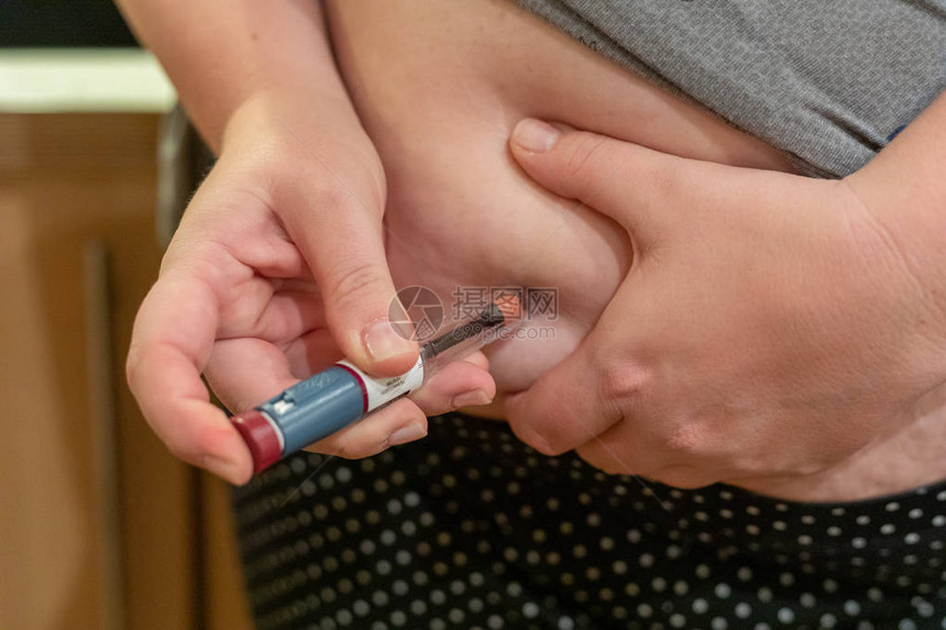 超重女向肥胖胃糖尿病注射胰岛素的特写镜头图片