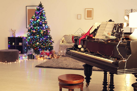 时尚的内部装饰着圣诞树和钢琴图片