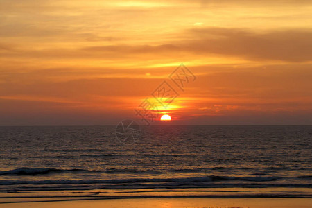 明亮的日落海面下有黄色的大太阳日落在背景图片