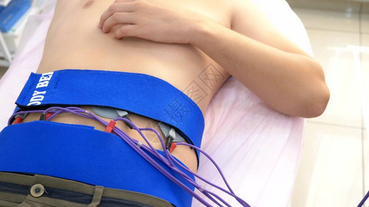 特写腹部肌肉的电刺激程序一个人被动地刺激腹部肌肉图片