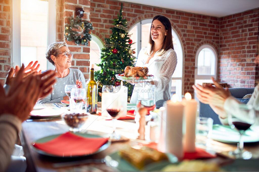 家人和朋友在家中用传统食物和装饰来庆祝圣诞节晚宴图片