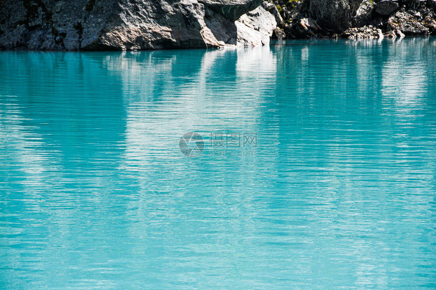 蓝色大海岸边的岩石绿松石山湖河面图片