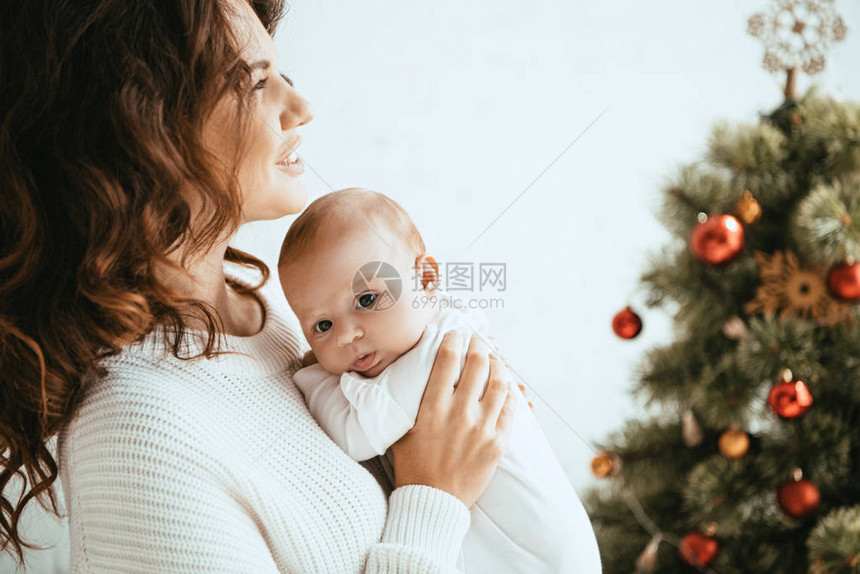 幸福的母亲抱着可爱的婴儿同时站图片