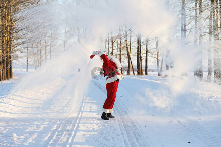 在冬天领域的圣诞老人圣诞老人神奇的雾沿着田野走圣诞前夜的圣诞老人带着红袍给图片