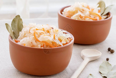 凉拌料包装在粘土碗里用胡萝卜关闭酸黄瓜是一种发酵的蔬菜典背景