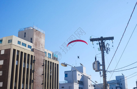 滑翔伞在夏日飞向蓝天从陆地上看扔草图片