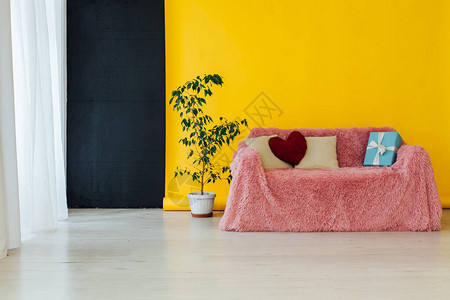 粉色沙发在有黄色背景的房图片