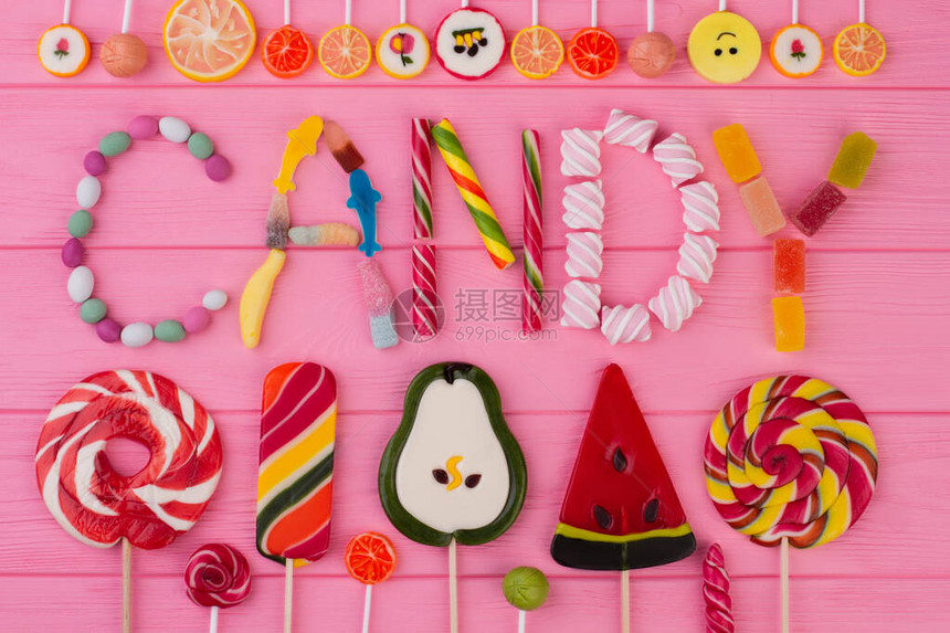 WordCANDY由五颜六色的糖果制成粉红色木制背景上不同糖果和图片