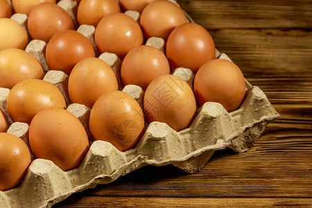 木桌上纸板蛋盒里的生鸡蛋图片