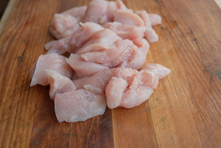 新鲜鸡肉放在桌子上的木板上选择焦点乡村风格生鸡肉片在家切鸡片图片