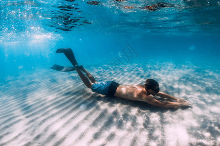 漂浮在沙地底水下的自由潜水滑翔有图片
