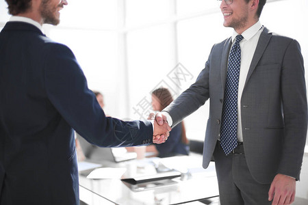 办公室内商业伙伴的可靠握手合作概念图片
