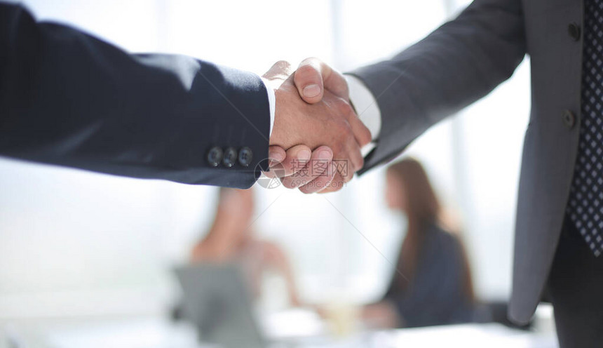 办公室内商业伙伴的可靠握手合作概念图片