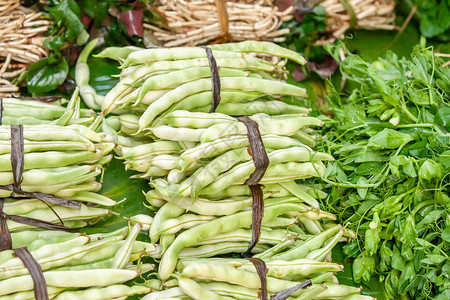 云南沙当地市场香蕉叶上新鲜茂盛的豇豆或亚德龙豆等蔬菜饮食图片