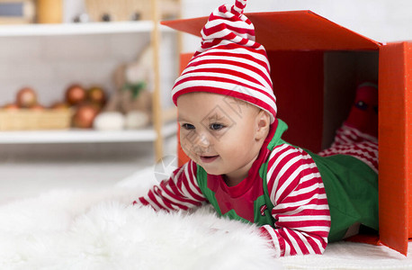 圣诞惊喜可爱的婴儿精灵爬出礼物盒寻图片