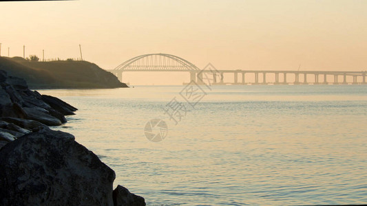 令人惊叹的日出天空在平静的海面上荡漾着涟漪和白色的高桥图片