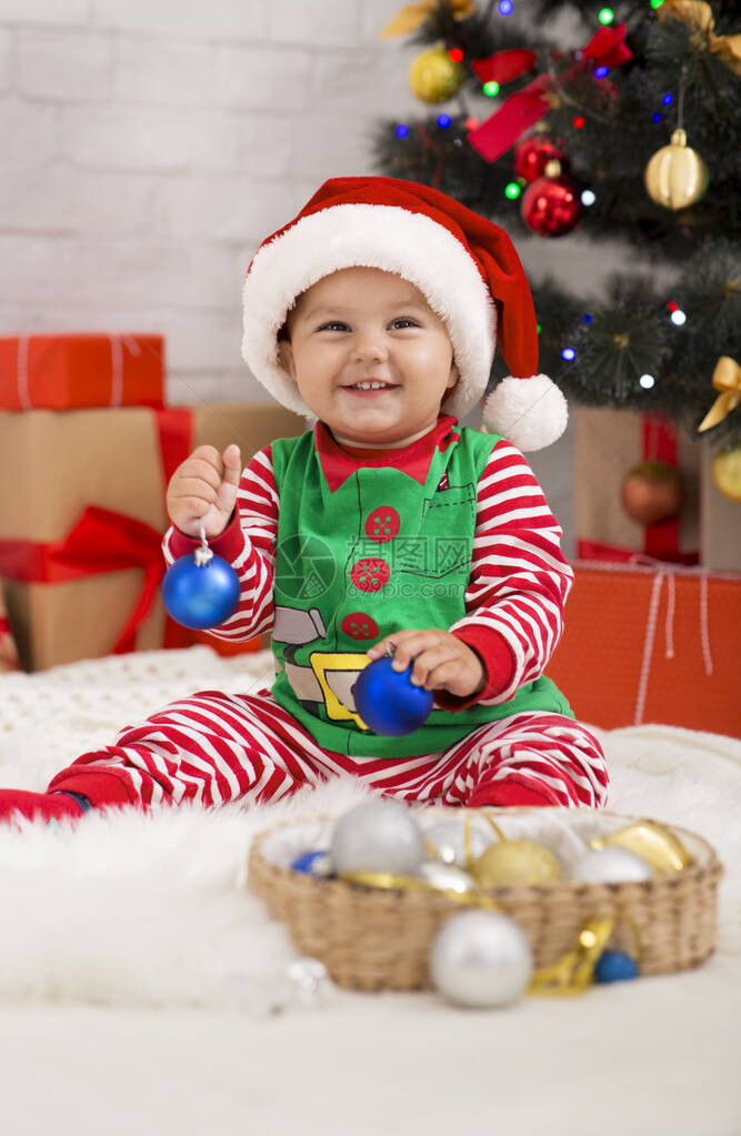 庆祝Xmas庆典积极的婴儿精灵在圣诞树下玩装图片