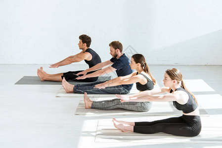 青年在运动服上做瑜伽坐在前方高清图片