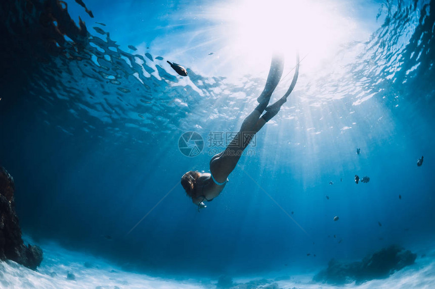 具有吸引力的女自由潜水员滑翔在沙海上图片