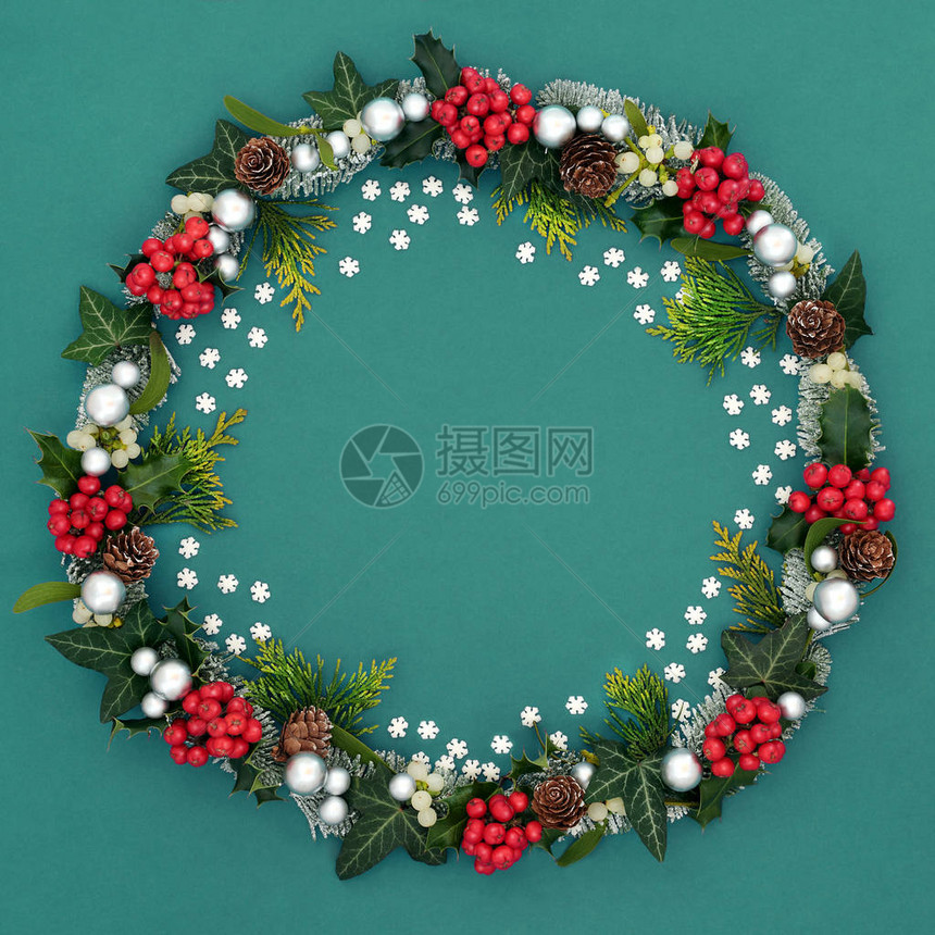 圣诞花环装饰有装饰雪花冬青浆果槲寄生云杉冷松果和绿色背景上的银球小玩意节图片