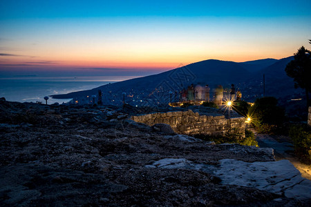 阿尔巴尼亚萨兰达Lekuresi城堡的蓝色小时早夜景观背景图片