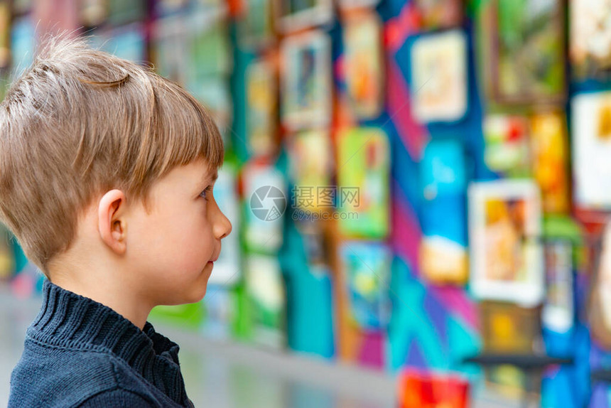 一个惊讶的男孩在艺术画廊的一个展图片