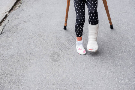 有断腿的小孩在街上拐杖上概念照片描述一个孩子在节假日学校背景图片
