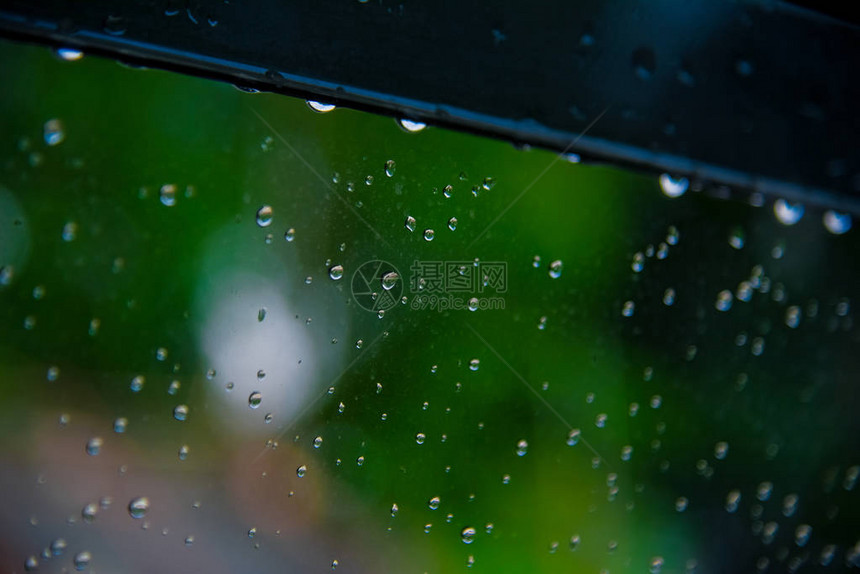 有绿树自然背景的玻璃上的雨滴浪漫片场景内容彩色雨滴图片