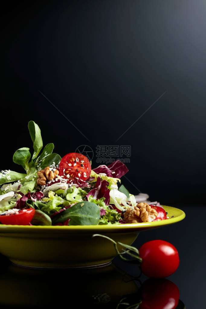 绿色沙拉配樱桃番茄核桃和植物油图片