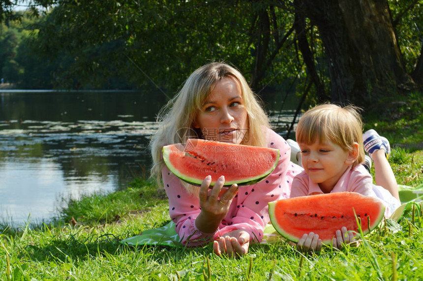 小男孩和妈在河边吃西瓜图片