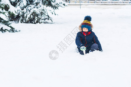 拿着铁锹在外面玩雪的男孩图片