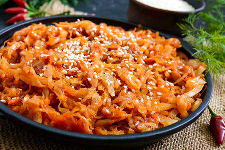 在黑色背景的铸铁煎锅中用番茄酱炖白菜四旬期菜单饮食低热量图片