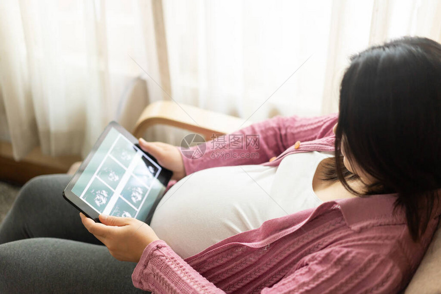 孕妇在照顾她未来的孩子的同时在家感到快乐产前护理和图片