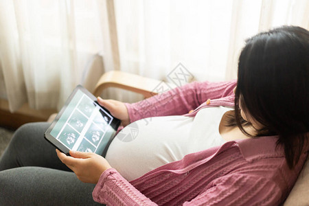 孕妇在照顾她未来的孩子的同时在家感到快乐产前护理和图片