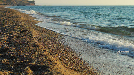沙子鹅卵石海滩日落时的小海浪景图片