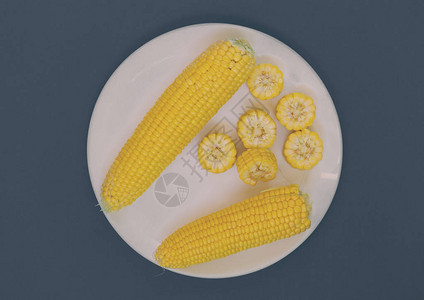 盘子上印着绿石背景的玉米玉米切片谷物图片