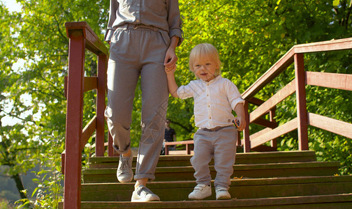 婴儿男孩在公园的桥上走着妈图片