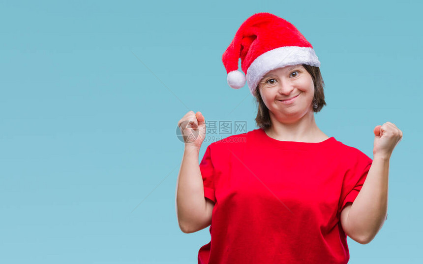 患有唐氏综合症的年轻成年女在孤立的下戴着圣诞帽图片
