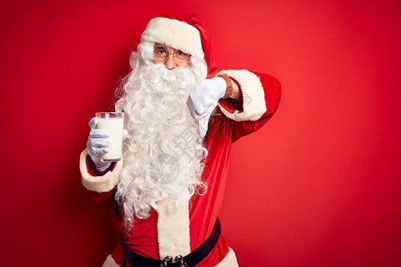 穿着圣诞老人服装的老人拿着一杯牛奶图片