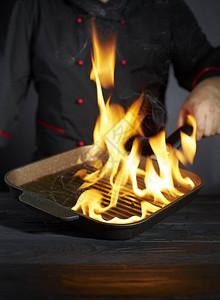 专业厨师在火焰上准备食物图片