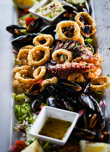 美味的混合油炸海鲜菜肴与章鱼虾贝壳鱿鱼和鲜鱼配图片