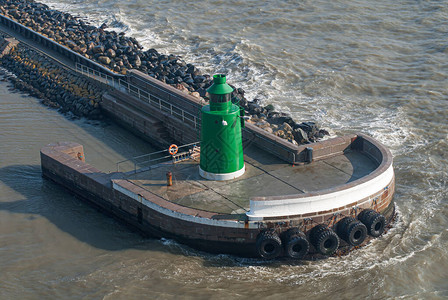 港口防波堤上的绿色航行灯图片