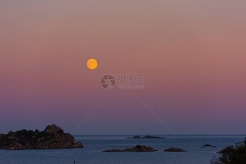 海洋上空的月亮升起前景是悬崖图片