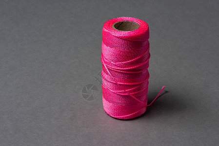 一卷灰色背景上的粉红色绳子图片