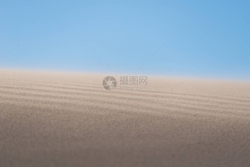 风吹过沙漠中的沙丘图片