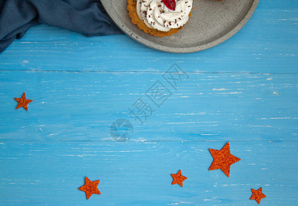 蓝色木桌上灰色板块上的奶油蛋糕图片