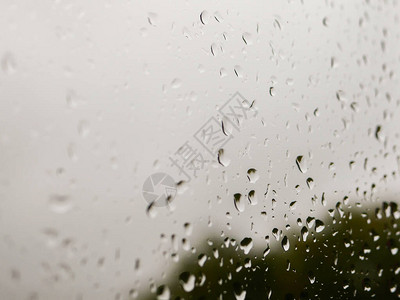 玻璃上的雨滴阴雨天气在自然模糊的背景下秋日窗上的雨滴图片