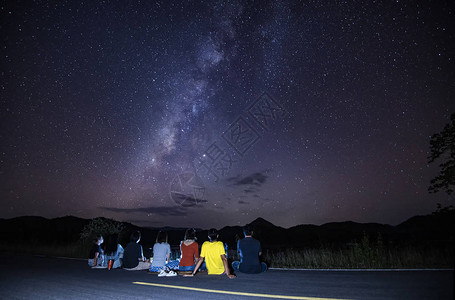 银河系与游客坐在路上看天空夜景五颜六色的星和山上泰国银河图片