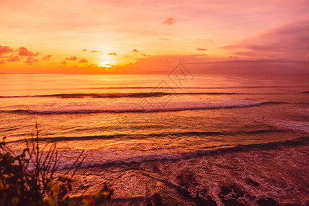 在巴厘岛冲浪的海浪和明亮的日落图片