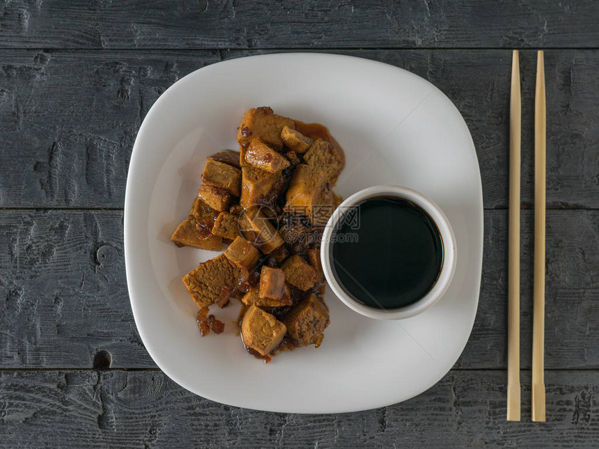 一碗豆腐和酱油放在木制桌子上蔬菜图片